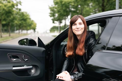 Elena Gantner looking at the camera from the front seat of a car