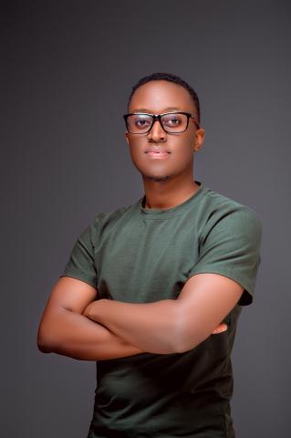 Young man with crossed arms standing and looking into the camera
