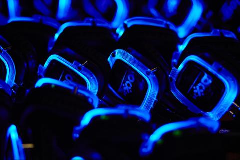 Multiple blue and black headphones lying on a table