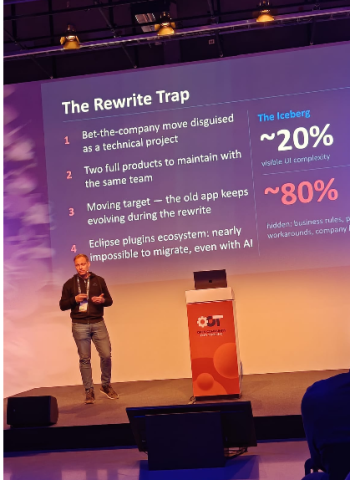 Sebastian Sampaoli presenting a slide titled ‘The Rewrite Trap’, outlining risks of rewriting software systems, including hidden complexity, parallel maintenance, and challenges in migrating ecosystems.