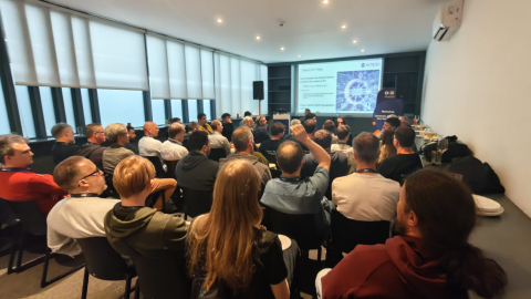 Workshop BoF audience discussion alongside a table of drinks and snacks at a community event.