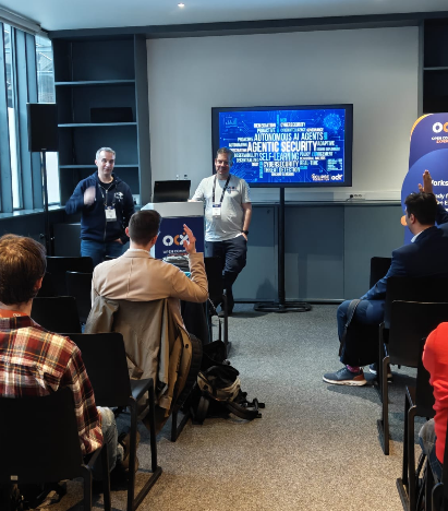Workshop session with two speakers (Michael Berns and Mikael Barbeiro) and audience interaction, discussing AI and security topics.